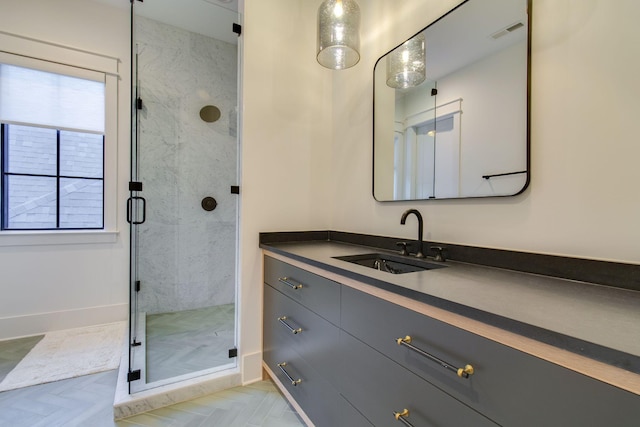 bathroom featuring vanity, an enclosed shower, and parquet flooring