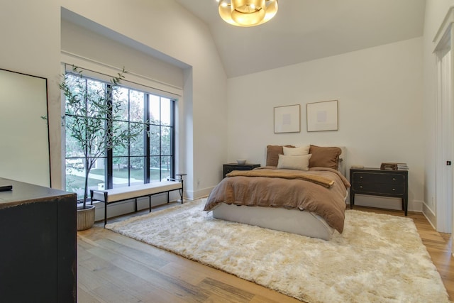 bedroom featuring lofted ceiling and light hardwood / wood-style flooring