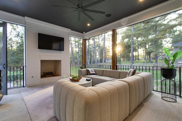 sunroom featuring an outdoor brick fireplace, ceiling fan, and wooden ceiling