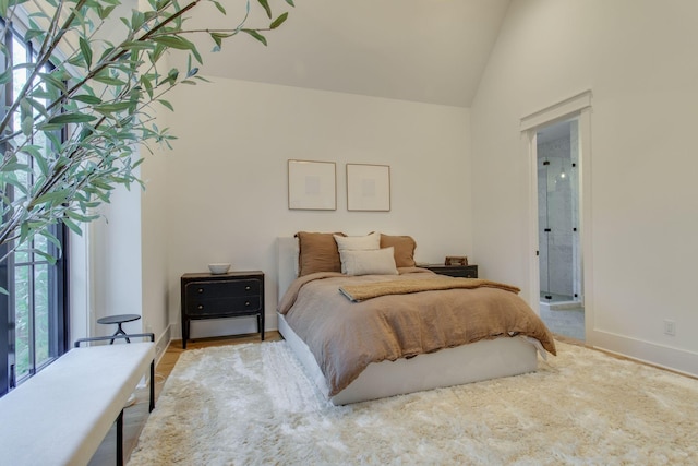 bedroom featuring connected bathroom and vaulted ceiling