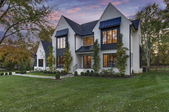 view of front of home featuring a yard and central AC unit