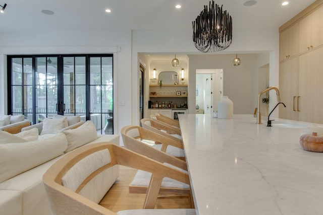 living room with sink, french doors, and a notable chandelier