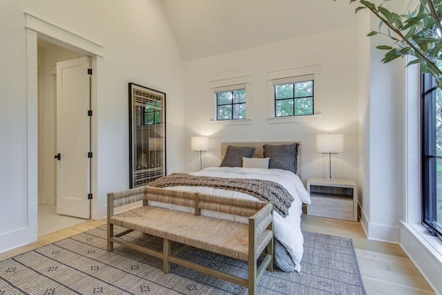 bedroom featuring light wood-type flooring and vaulted ceiling