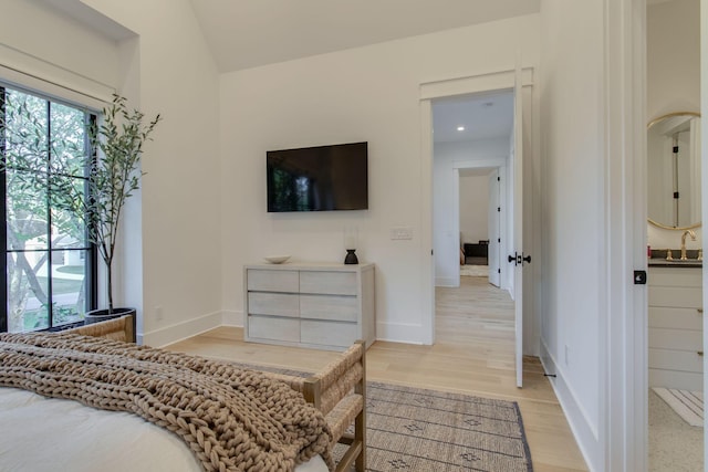 bedroom with light wood-type flooring and sink