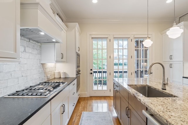 kitchen featuring premium range hood, white cabinetry, sink, and stainless steel appliances