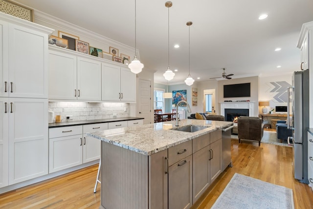 kitchen featuring white cabinetry, sink, and hanging light fixtures