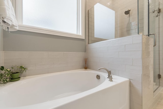 bathroom featuring separate shower and tub and a wealth of natural light