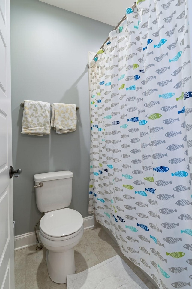 bathroom featuring tile patterned floors, a shower with curtain, and toilet