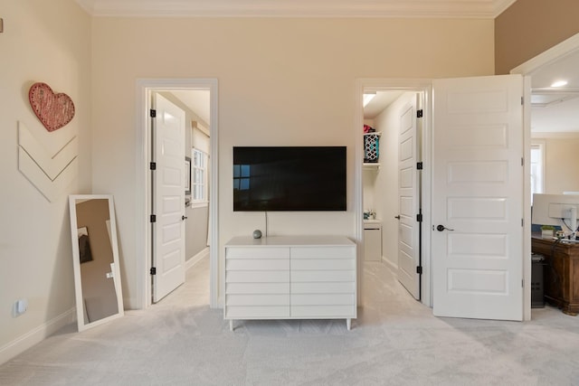 bedroom with light carpet, crown molding, and ensuite bathroom