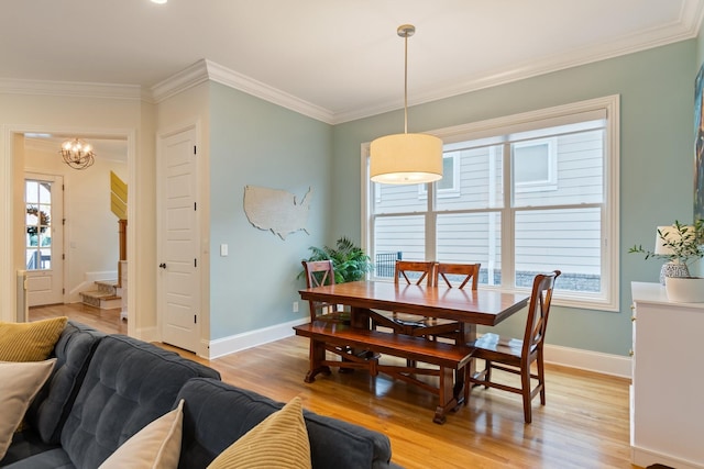 dining space with ornamental molding and light wood-type flooring