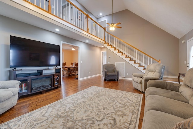 living room with hardwood / wood-style floors, high vaulted ceiling, and ceiling fan