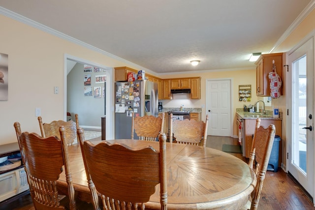 dining room with sink, dark wood-type flooring, and ornamental molding