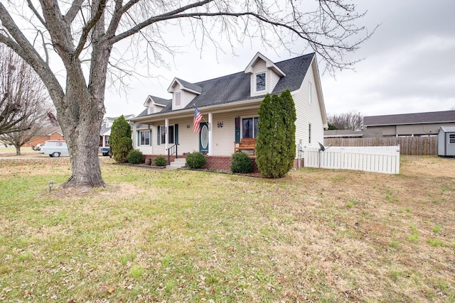 cape cod-style house with covered porch and a front yard