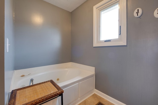 bathroom with tile patterned floors, a bathtub, and a textured ceiling