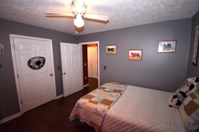 bedroom with ceiling fan, dark hardwood / wood-style flooring, and a textured ceiling