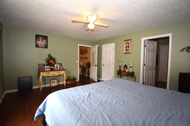 bedroom featuring a textured ceiling, dark wood-type flooring, and ceiling fan