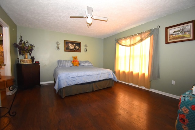 bedroom featuring ceiling fan, dark hardwood / wood-style flooring, and a textured ceiling