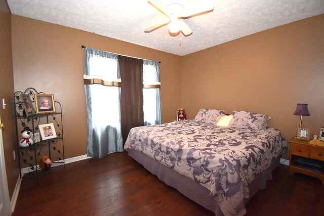 bedroom with dark hardwood / wood-style flooring, a textured ceiling, and ceiling fan