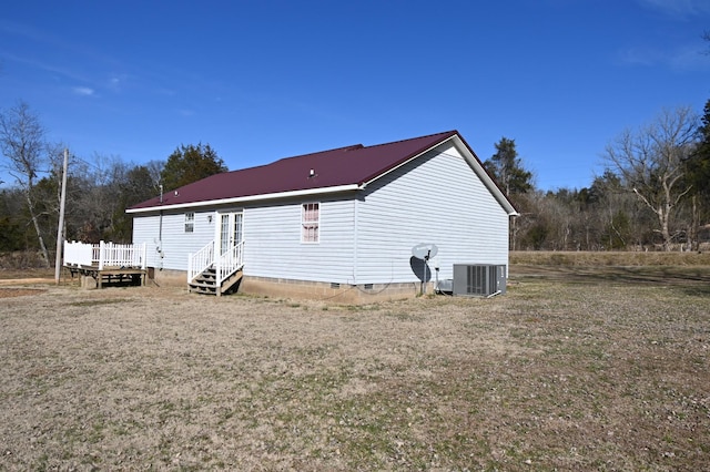 rear view of property featuring central AC unit and a yard