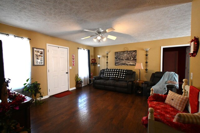 living room featuring ceiling fan, dark hardwood / wood-style floors, a wealth of natural light, and a textured ceiling