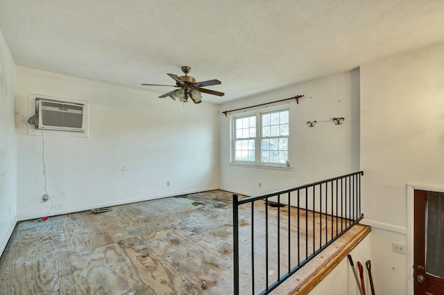 spare room featuring ceiling fan, a textured ceiling, and a wall mounted AC