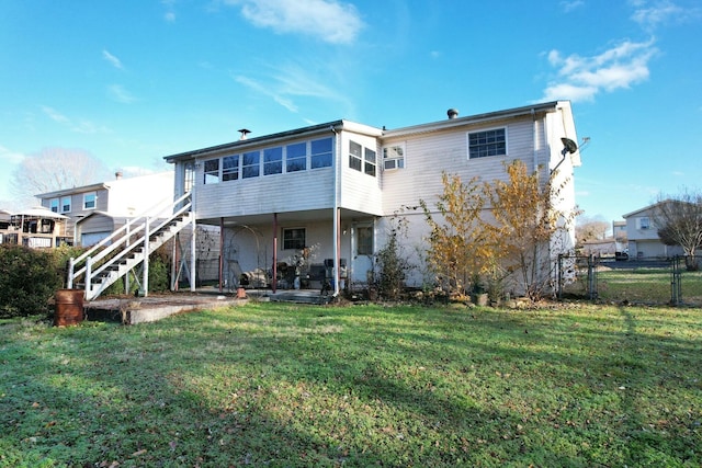 rear view of property with a lawn and a sunroom