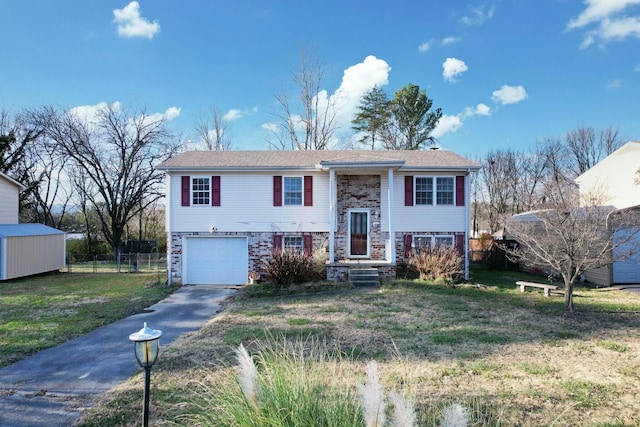 raised ranch featuring a garage and a front lawn