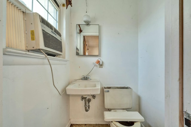 bathroom with cooling unit, toilet, and sink