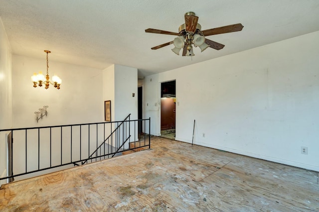 unfurnished room with ceiling fan with notable chandelier