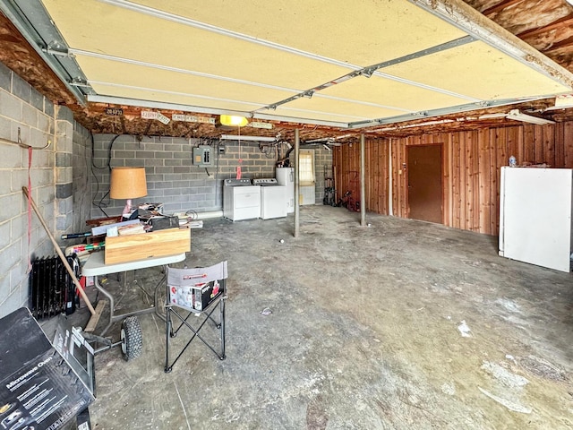 garage featuring electric panel and washer and dryer