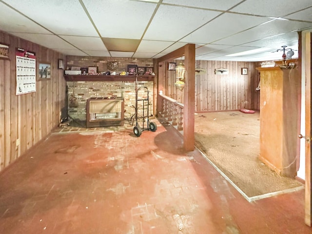 basement with a paneled ceiling and wooden walls