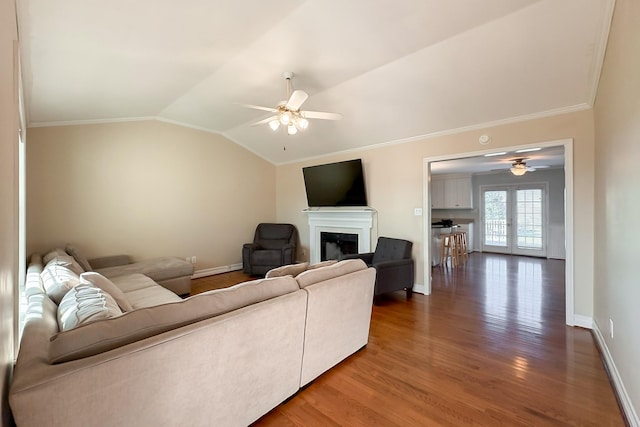 living room featuring vaulted ceiling, dark hardwood / wood-style floors, crown molding, and ceiling fan