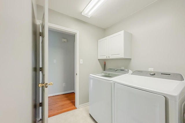 washroom with cabinets and washer and clothes dryer