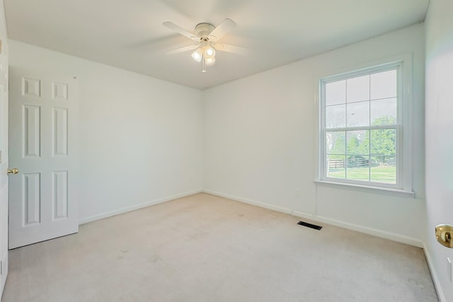 carpeted empty room featuring a wealth of natural light and ceiling fan