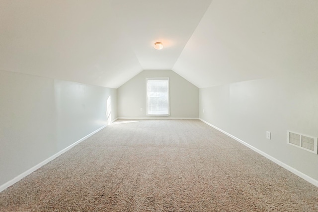 bonus room with lofted ceiling and carpet