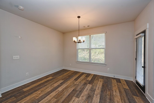 unfurnished room featuring a notable chandelier and dark wood-type flooring