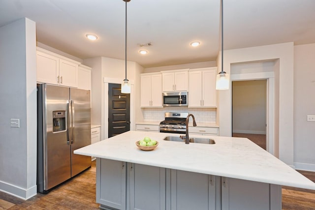 kitchen featuring decorative light fixtures, a kitchen island with sink, and appliances with stainless steel finishes