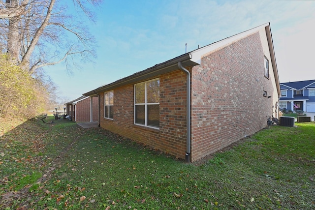 view of home's exterior with central AC unit and a yard