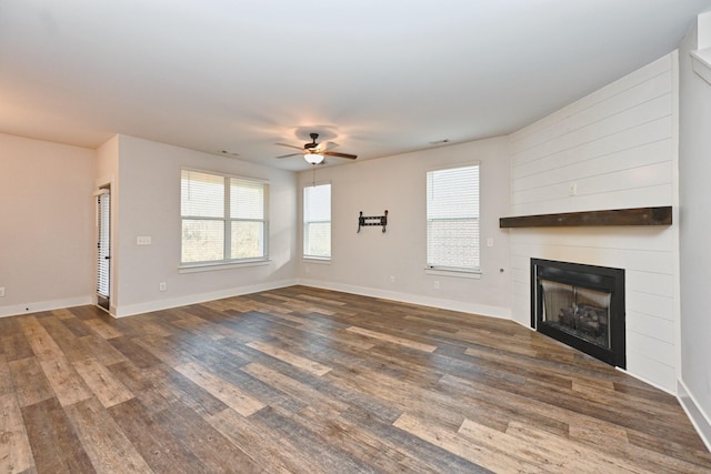 unfurnished living room featuring ceiling fan and dark hardwood / wood-style flooring