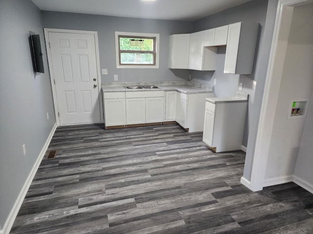 kitchen featuring dark hardwood / wood-style flooring, white cabinets, and sink