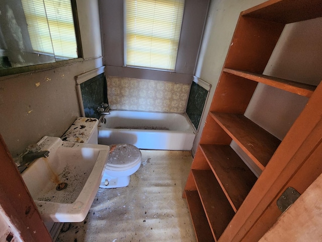 bathroom featuring sink, toilet, and a bath