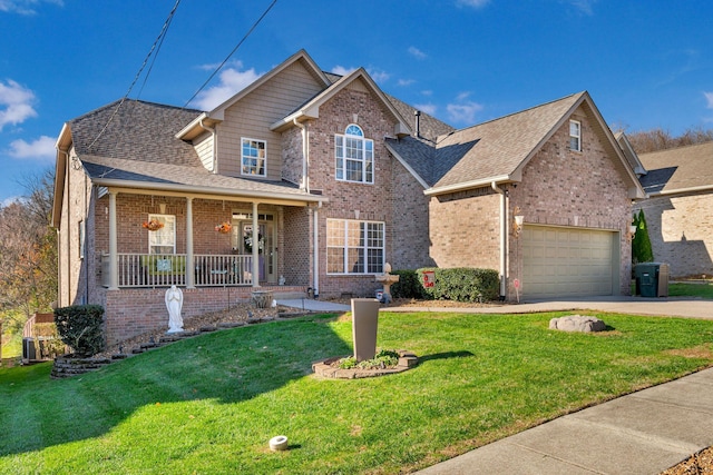 view of property with a garage, covered porch, and a front lawn