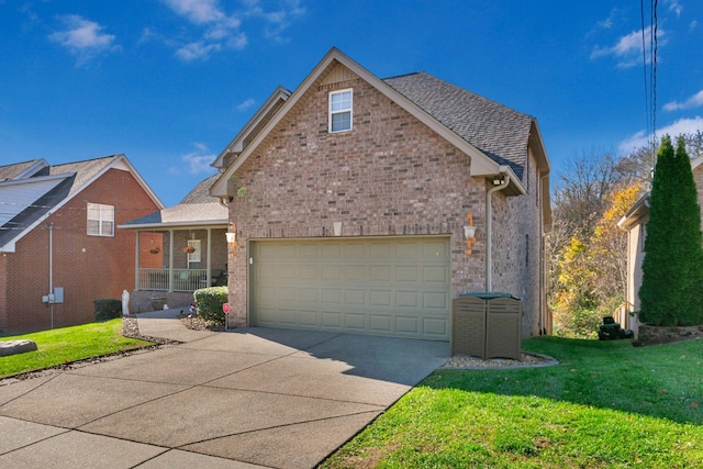 front of property featuring a front lawn, covered porch, and a garage