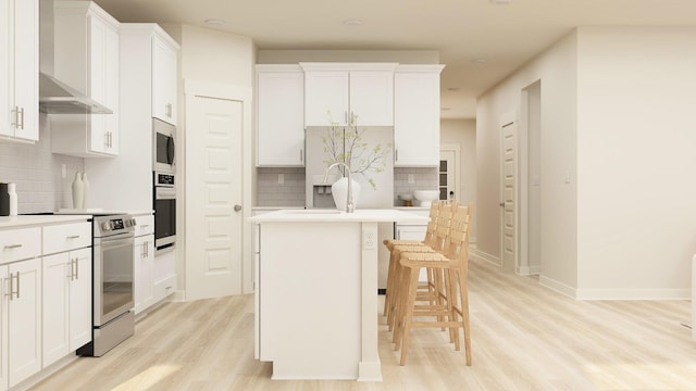 kitchen featuring white cabinets, a kitchen breakfast bar, stainless steel appliances, and tasteful backsplash