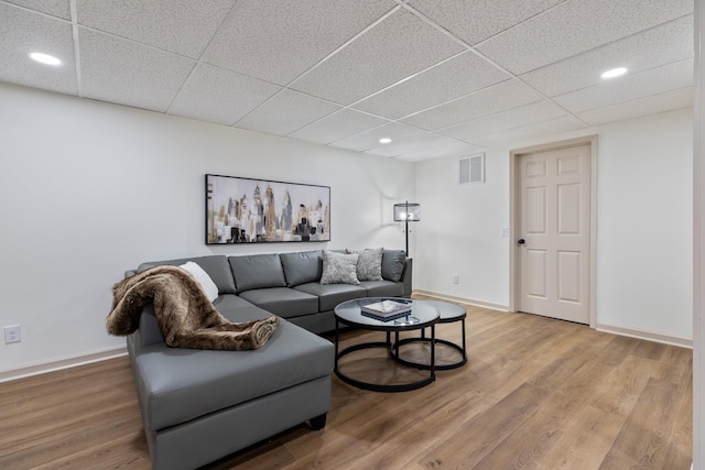 living room featuring a drop ceiling and hardwood / wood-style flooring