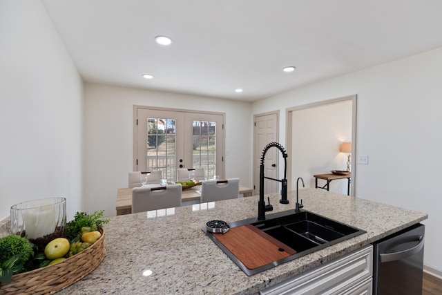 kitchen with light stone countertops, sink, wood-type flooring, and french doors