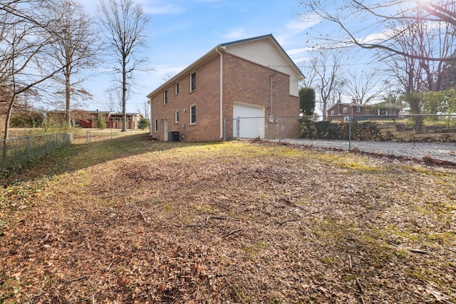 view of property exterior with a garage and central AC unit