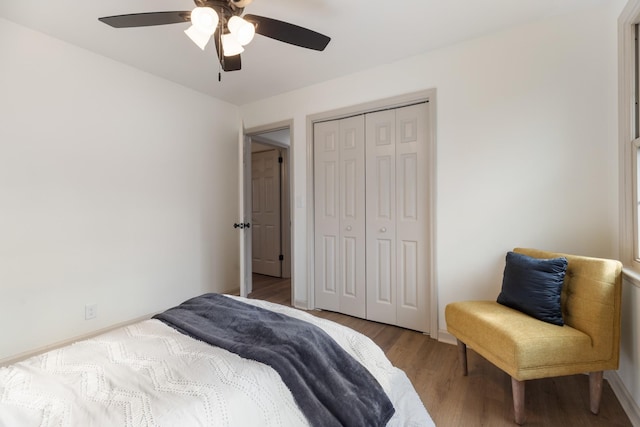 bedroom with hardwood / wood-style floors, a closet, and ceiling fan