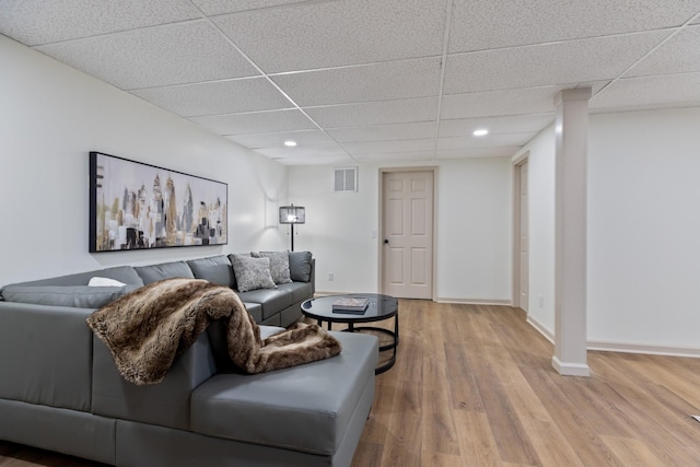 living room featuring a paneled ceiling and light hardwood / wood-style flooring