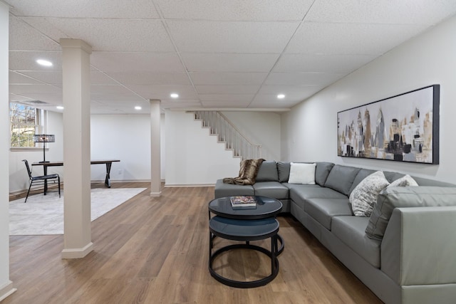 living room with wood-type flooring and a drop ceiling